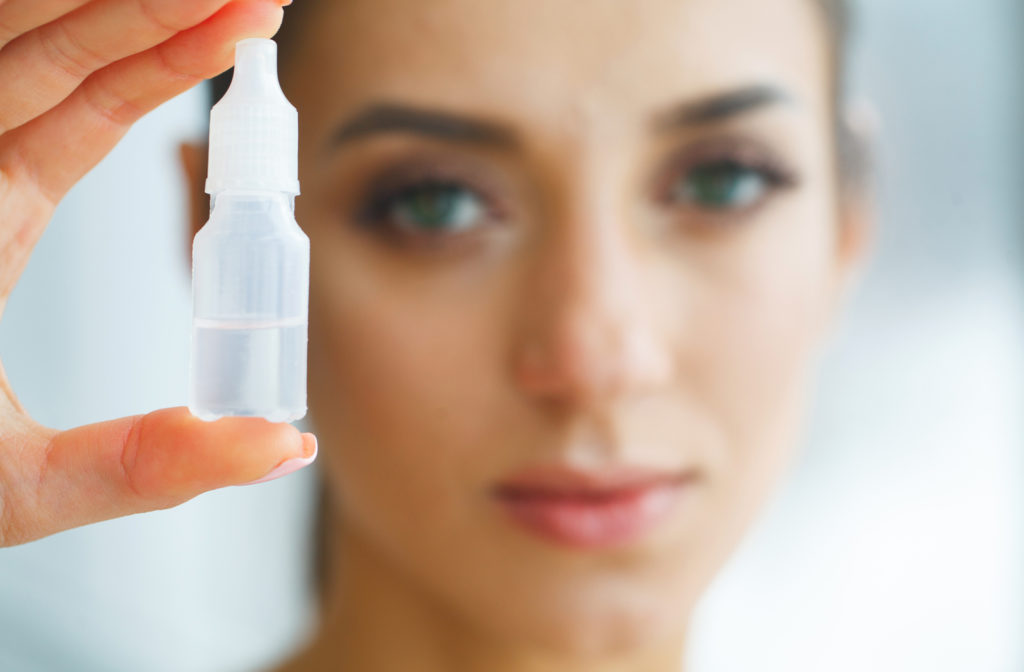 Close up of blurred women holding eye drops prior to putting them in her eye