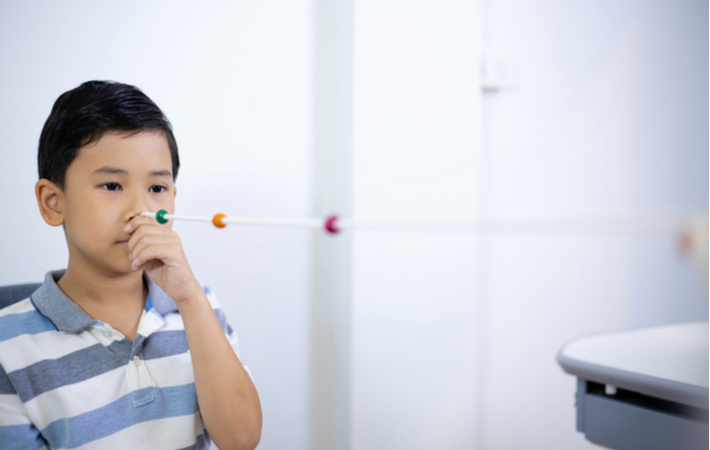 Young boy undergoing vision therapy at eye doctor office