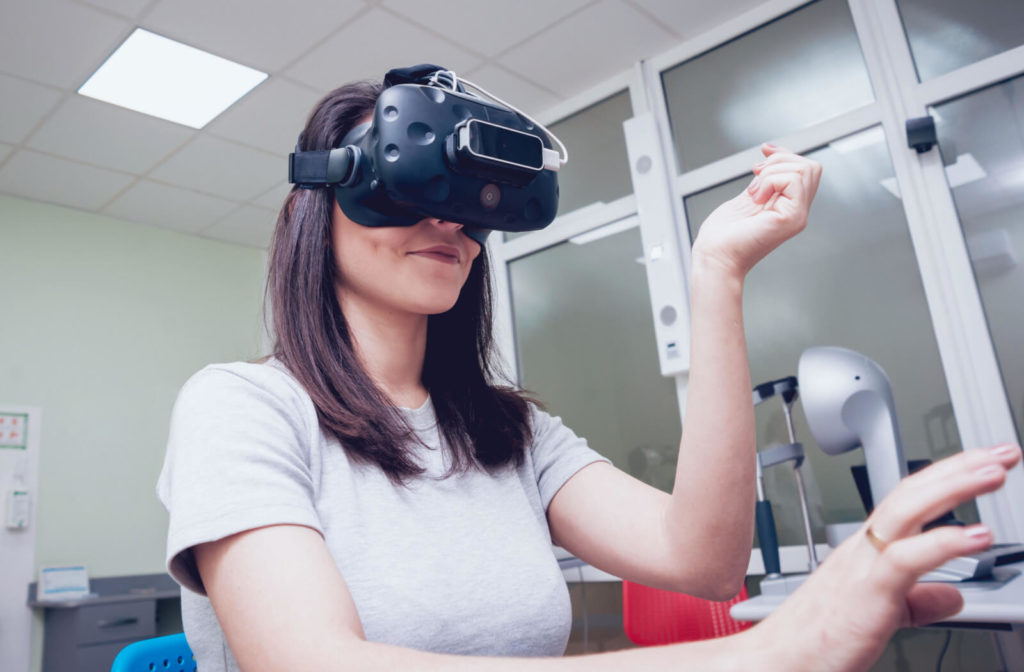 A female patient wearing visual reality goggles is undergoing visual therapy.