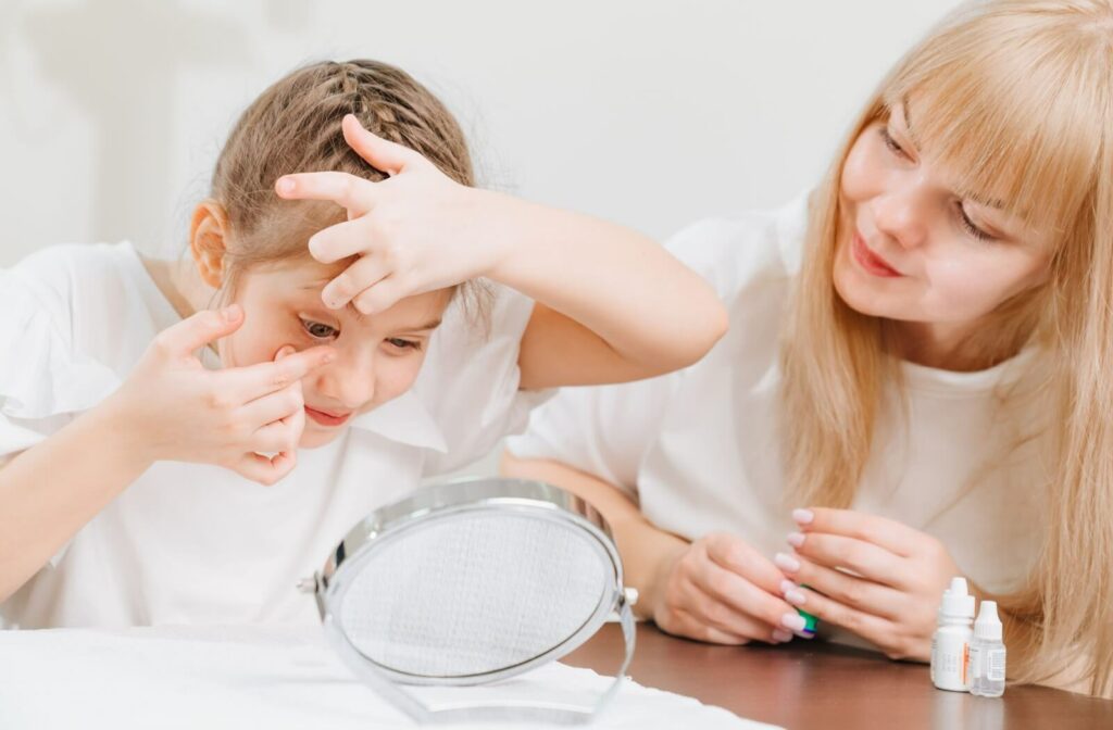 An optometrist teaches a young patient how to properly insert and care for contact lenses to help prevent dry eye symptoms