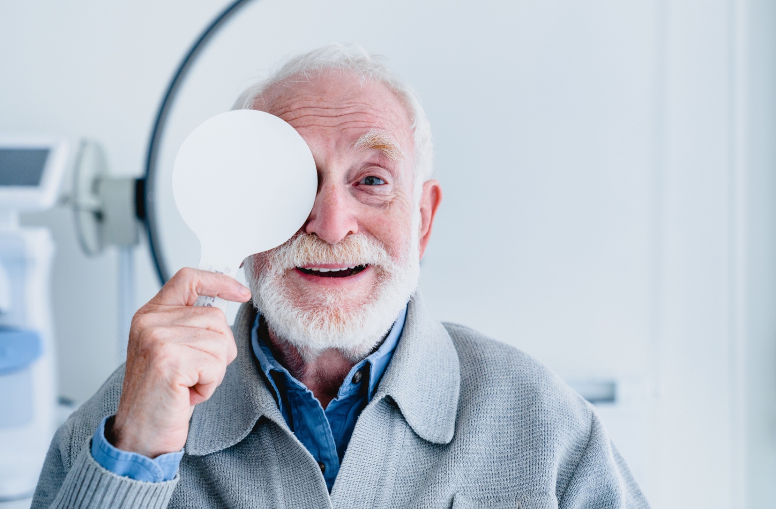 A mature patient covers their right eye during an annual diabetic eye exam.