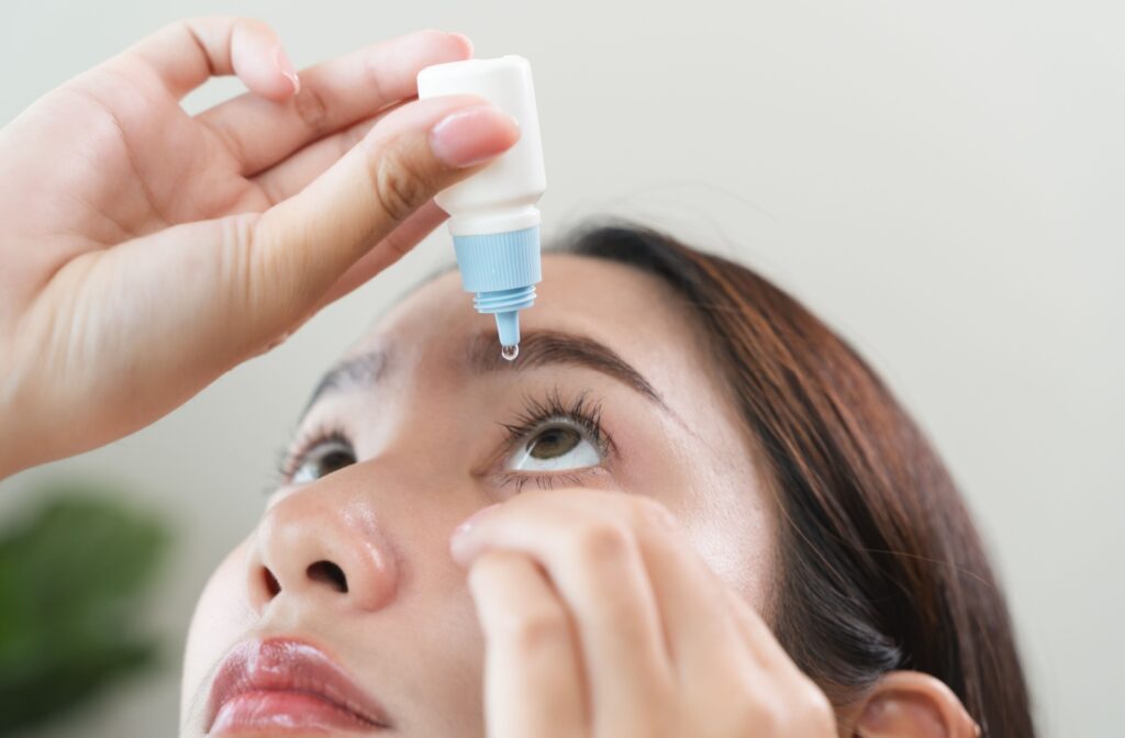 A person pulls down their eyelid to apply eye drops to relieve their dry eye syndrome.