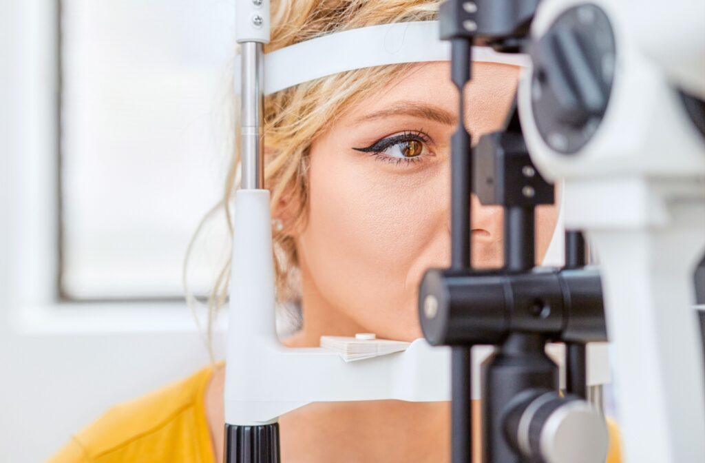 A close-up image of a patient during a contact lens exam while an optometrist performs a slit-lamp test.