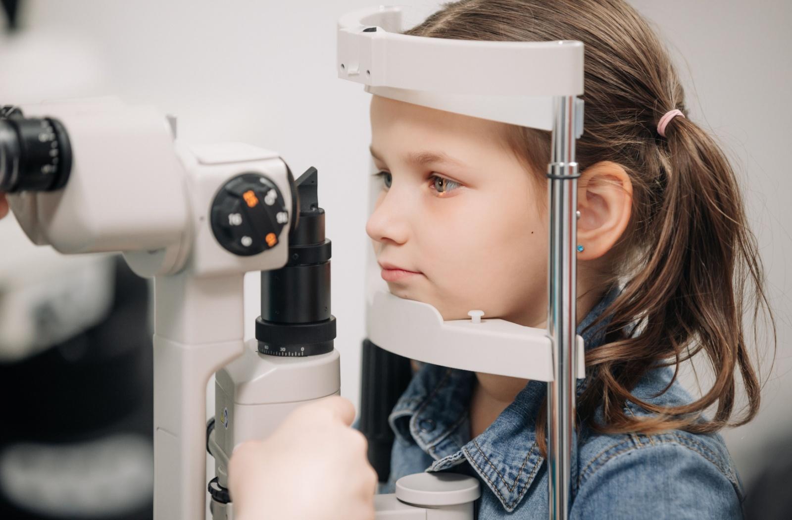 a child undergoing a slit lamp eye test during a routine eye exam