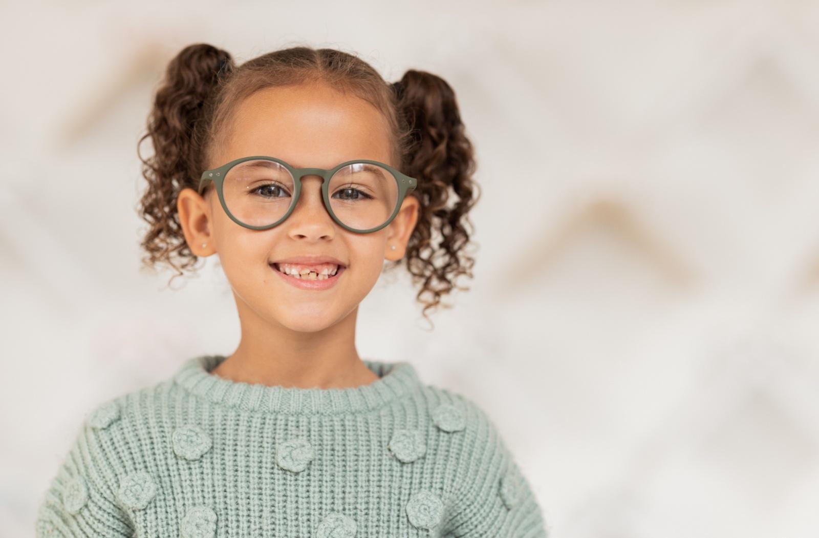A child wearing glasses while wearing a green shirt